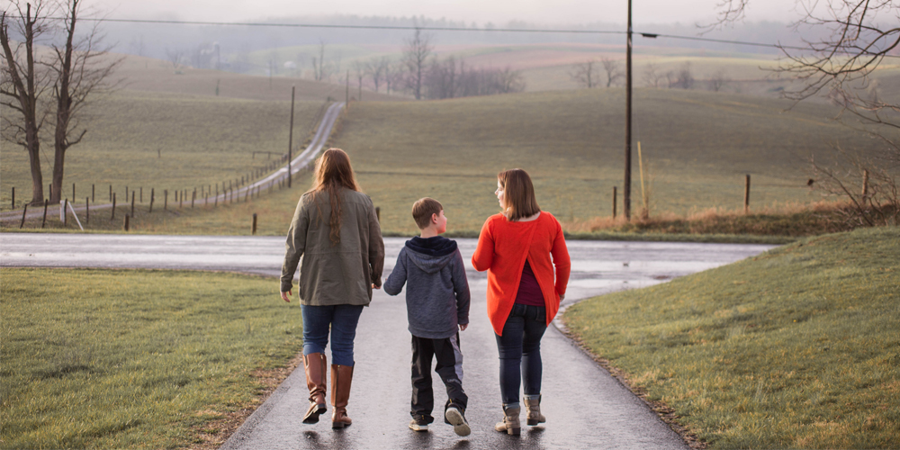photo of two students and a child taking a walk outdoors